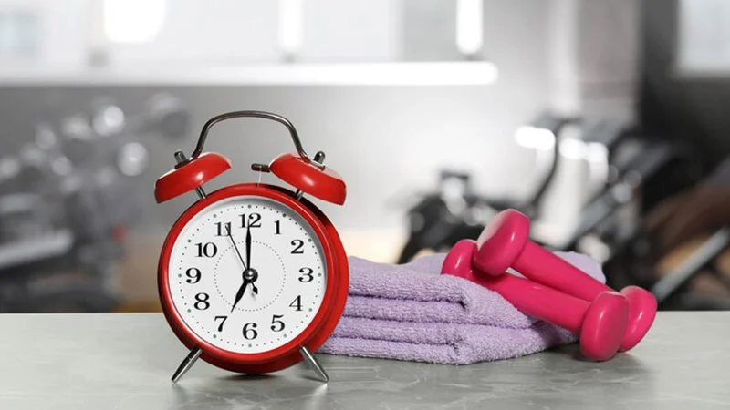 عکسی از ساعت و دمبل ورزشی در کنار هم برای نمایش مفهوم تمپو در بدنسازی 